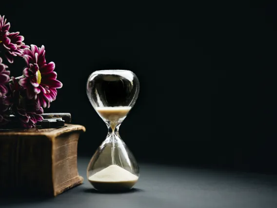 An hourglass filled with sand on a black background